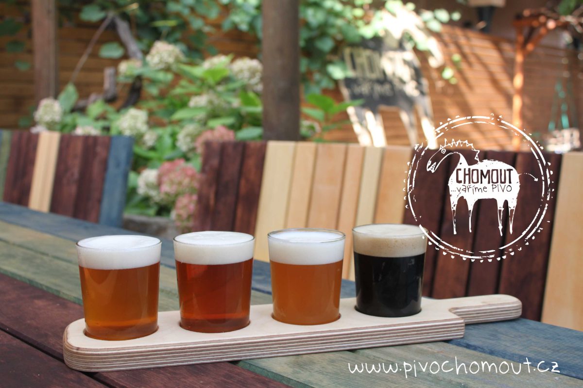 Čtveřice degustačních sklenic Chomout na dřevěném prkénku na zahrádce pivovaru